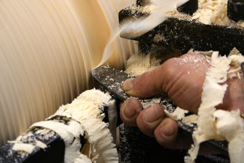 main de l'artiste au travail sur le tour à bois